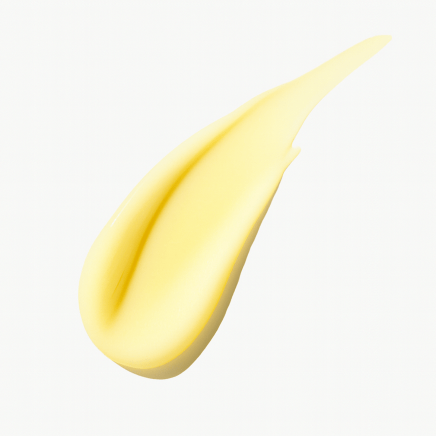 Yellow cream or hair product swatch on white background.