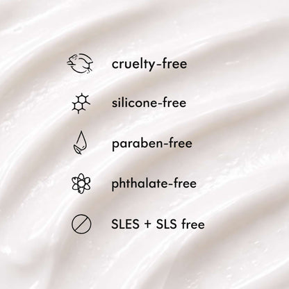 Close-up of a smooth, white cream texture with 'cruelty-free', 'silicone-free', 'paraben-free', 'phthalate-free', and 'SLES + SLS free' labels.