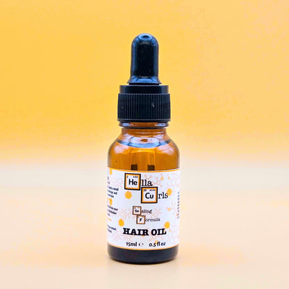 Bottle of Hella Curls Sealing Formula hair oil with a dropper on a gradient yellow background