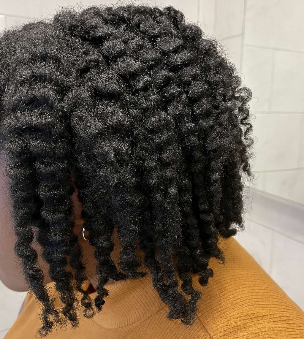 Person with styled black hair in a bathroom setting
